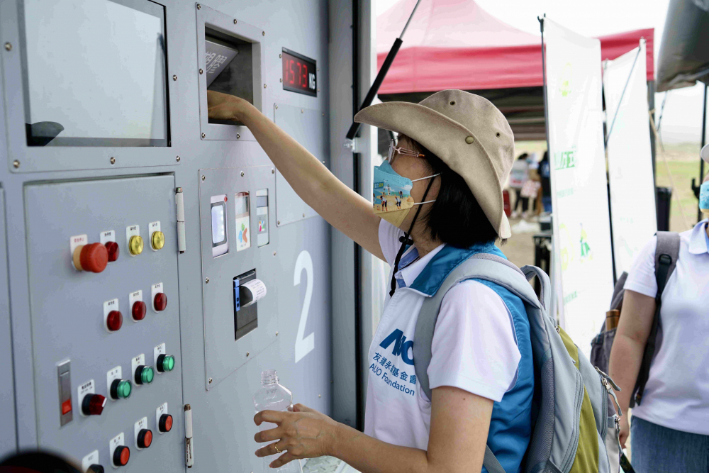 志工們將拾起的寶特瓶投入「好歸塑專車」，讓廢棄塑料空瓶可以直接粉碎、縮小體積，未來將可再製成購物袋、寶特衣、悠遊卡等生活用品